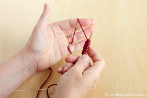 hook yarn over pointer finger - blossomsandposies.com